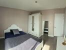 Spacious bedroom with double bed, wardrobe, and a large window