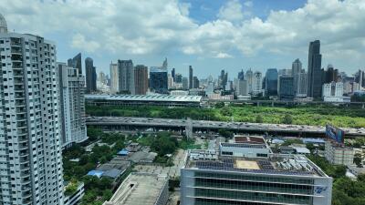 High-rise buildings in a city with green spaces and a highway