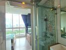 Modern bathroom with glass shower and view of the bedroom