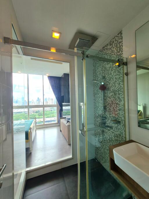 Modern bathroom with glass shower and view of the bedroom