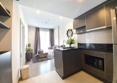 Modern kitchen and living area with black cabinetry and open layout