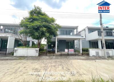 Front view of a modern two-story house with a fenced yard and driveway