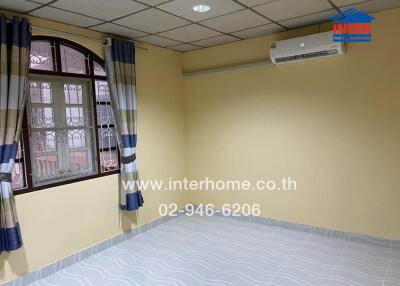 Empty bedroom with tiled floor, curtain, window, and air conditioner