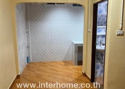 Hallway in a real estate property with tiled floors and an open entrance.