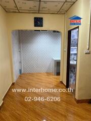 Hallway in a real estate property with tiled floors and an open entrance.