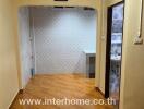 Hallway in a real estate property with tiled floors and an open entrance.