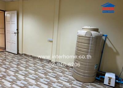 Utility room with water tank and tiled flooring