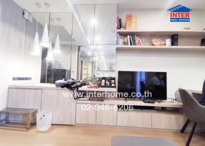 Living area with shelves, TV, and pendant lights