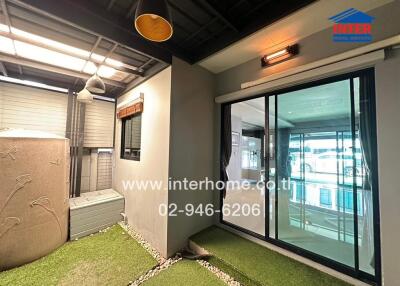 Covered outdoor space with artificial grass and sliding glass door