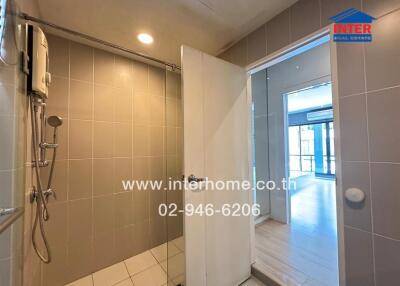 Bathroom with shower area and door slightly open leading to another room