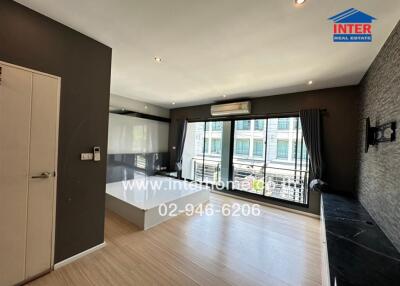 Modern bedroom with wooden flooring and large windows