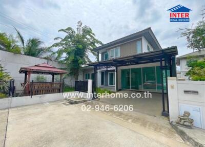 Front view of a modern house with driveway and garden gazebo