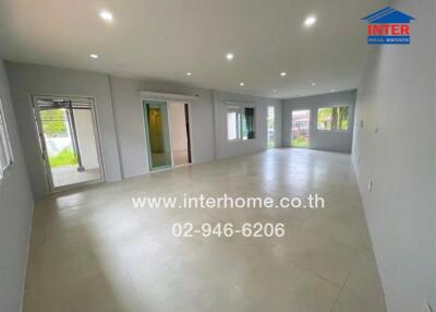 Spacious empty living room with large windows and recessed lighting