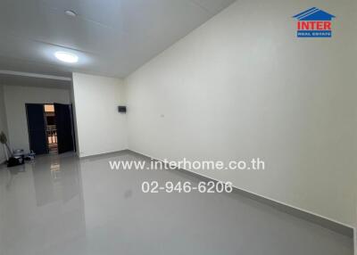 Spacious living area with tiled flooring and white walls