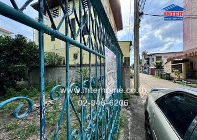 Exterior view of the property featuring a blue gate and adjacent car