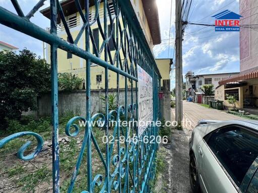 Exterior view of the property featuring a blue gate and adjacent car