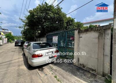 Exterior view of gated entrance with parked cars