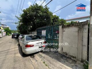 Exterior view of gated entrance with parked cars