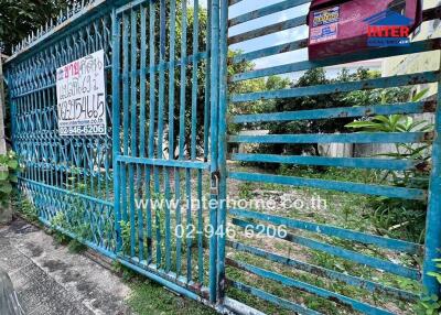 Gate view of property with contact information