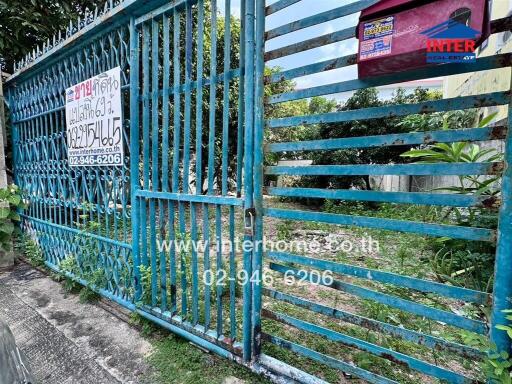 Gate view of property with contact information