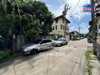 Street view with parked cars in front of residential buildings