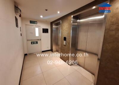 Elevator lobby with two elevators and an emergency exit door