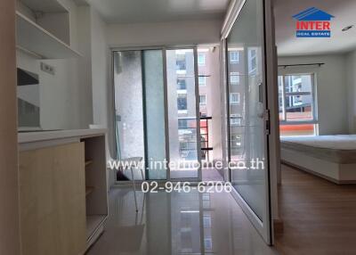 Photo of a bedroom with glass sliding doors, natural light, and adjacent balcony.