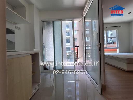 Photo of a bedroom with glass sliding doors, natural light, and adjacent balcony.