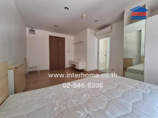 Bedroom with mattress, air conditioner, and wall-mounted desk