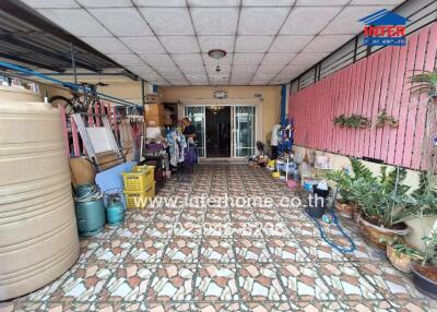 Covered outdoor entrance area with various storage items