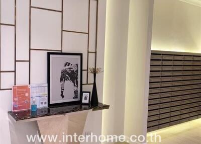 Lobby area with decorative wall panel, console table, and air conditioner