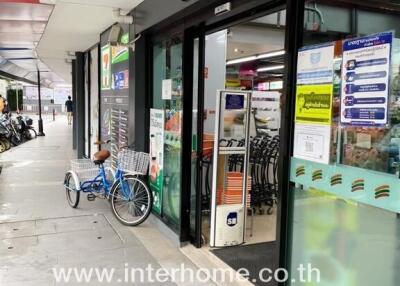 Convenience store entrance with bicycle, interhome real estate signage