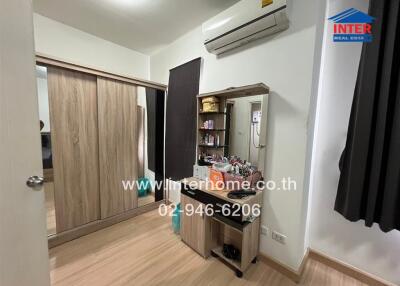 Bedroom with wooden flooring, built-in wardrobe, and dressing table