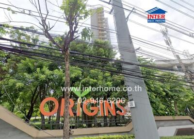 Entrance of a building complex with trees and power lines