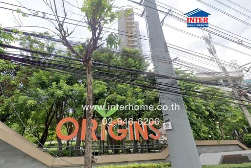 Entrance of a building complex with trees and power lines