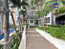 Entrance of residential building with landscaped walkway and pool