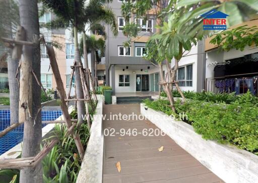 Entrance of residential building with landscaped walkway and pool