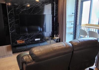 Modern living room with leather sofa and wall-mounted TV