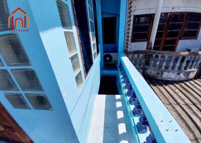 A balcony with blue walls and railings in a residential building.