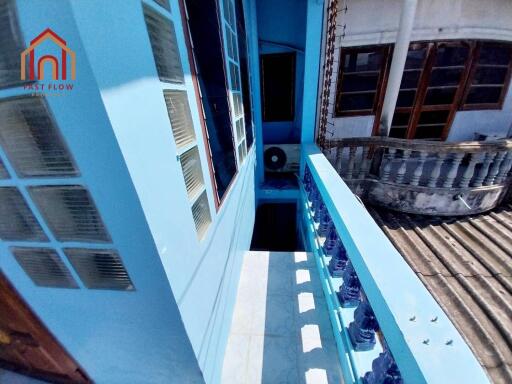 A balcony with blue walls and railings in a residential building.