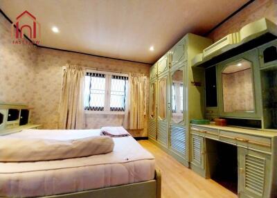 Spacious bedroom with built-in furniture and ample natural light