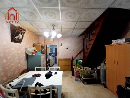 Dining area with table, chairs, staircase, and storage spaces