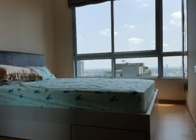 Modern bedroom with a large window and city view