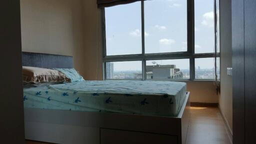 Modern bedroom with a large window and city view