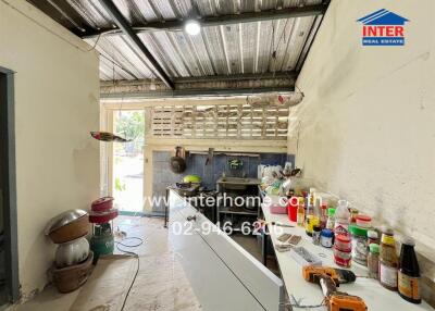 A spacious kitchen with a metal ceiling, white walls, and ample counter space.