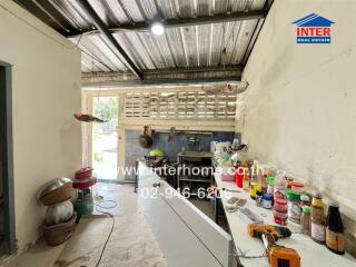 A spacious kitchen with a metal ceiling, white walls, and ample counter space.