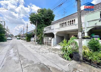 Street view of a residential area with houses and greenery