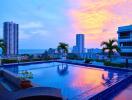 Rooftop pool with city and ocean view during sunset