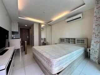 Modern bedroom with a wall-mounted air conditioner, large bed, mirrored wardrobe, and a small dining area