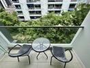 Balcony with chairs and table overlooking greenery